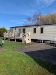 a large white house with a porch and a building at 29 Morningside at Southview in Skegness - Park Dean resorts in Lincolnshire