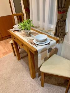 a wooden table with plates and dishes on it at 29 Morningside at Southview in Skegness - Park Dean resorts in Lincolnshire