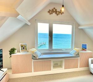 asiento junto a la ventana en una habitación con vistas al océano en Pier View Retreat - Close to Beach - Sea Views With Parking, en Bournemouth