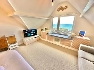 a living room with a large window and a television at Pier View Retreat - 5 Mins Walk to Beach - Sea Views With Parking in Bournemouth