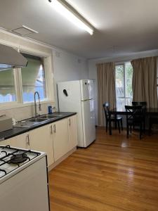 a kitchen with a white refrigerator and a table at E电车公交商圈大学附近别墅大床间Neighbors of chain supermarkets in Melbourne