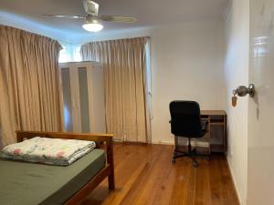 a bedroom with a bed and a desk and a chair at E电车公交商圈大学附近别墅大床间Neighbors of chain supermarkets in Melbourne