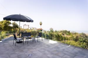 a patio with a table and chairs and an umbrella at Nice Apartment in rural environment in La Orotava