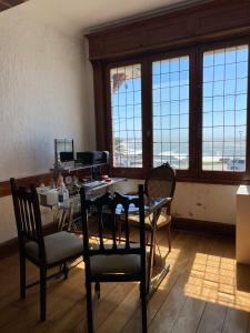 a dining room with a table and chairs and windows at Hotel con Hermosa Vista al Mar MDQ in Mar del Plata