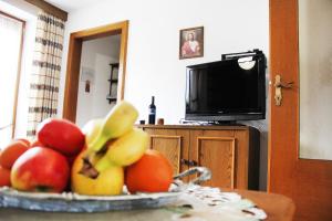 - un bol de fruits sur une table avec une télévision dans l'établissement Appartements Hanni, à Ehrwald