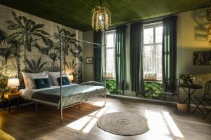 um quarto com uma cama num quarto com paredes verdes em Apartament Palmiarnia przy Zamkowej w Wałbrzychu em Wałbrzych