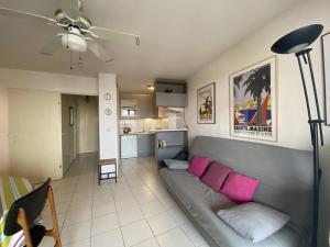 uma sala de estar com um sofá cinzento com almofadas cor-de-rosa em Appartement Canet-Plage, 3 pièces, 6 personnes - FR-1-750-51 em Canet-en-Roussillon