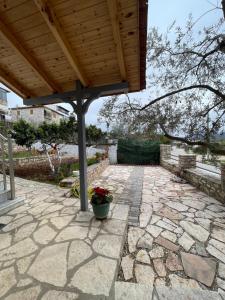 a patio with a wooden roof and a potted plant at Eveline Boutique Apartments in Sarandë