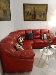 a red leather couch in a living room at Gregorihouseroma in Rome