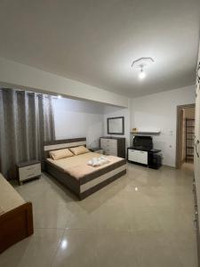 a bedroom with a bed and a television in it at Eveline Boutique Apartments in Sarandë