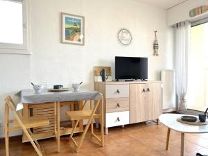 salon ze stołem i telewizorem w obiekcie Studio calme avec coin nuit, terrasse et parking - Proche plage et commerces - FR-1-251-420 w mieście Le Lavandou