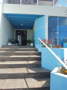 um edifício azul e branco com escadas e plantas em HOTEL PORTO FINO em Pontal do Paraná