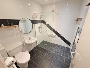 a bathroom with a toilet and a sink and a mirror at Ridgeway in Leighton Buzzard