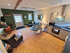 een keuken en een woonkamer met een tafel en een bank bij Barley End in Leighton Buzzard
