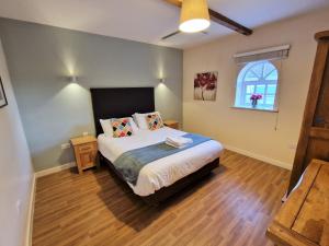 een slaapkamer met een groot bed en een raam bij Barley End in Leighton Buzzard