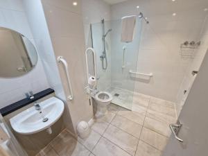 a bathroom with a shower and a toilet and a sink at Barley End in Leighton Buzzard