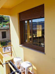 uma varanda com 2 bancos e uma janela em Estudio con vistas al mar em Moaña