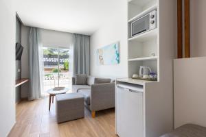 een kleine woonkamer met een bank en een tafel bij Mar Hotels Playa Mar & Spa in Port de Pollença