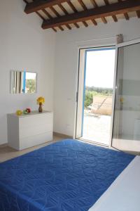 una camera da letto con moquette blu e una grande porta scorrevole in vetro di Terradimare a Trapani