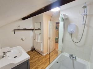 a bathroom with a sink and a shower at Barnyard Cottage in Leighton Buzzard