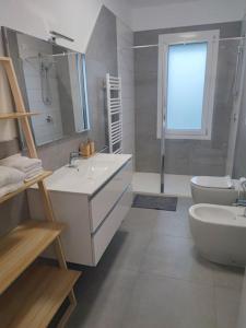 bagno bianco con 2 lavandini e servizi igienici di Villa Emily appartamento a Ca Tiepolo