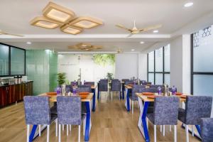 a conference room with tables and chairs and a screen at The Balcony Suites in Hyderabad