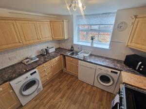 a kitchen with a sink and two washing machines at The Granary in Leighton Buzzard