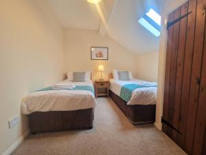 two twin beds in a room with a window at The Granary in Leighton Buzzard