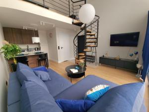 sala de estar con sofá azul y cocina en Green House Jugów 