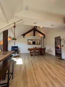 ein offenes Wohnzimmer mit Holzböden und einem Tisch in der Unterkunft Cocon sous les toits in Albertville