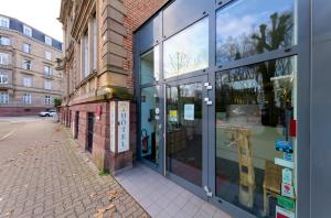 ein Gebäude mit Glasfenstern an der Straßenseite in der Unterkunft Adonis Hotel Strasbourg in Straßburg