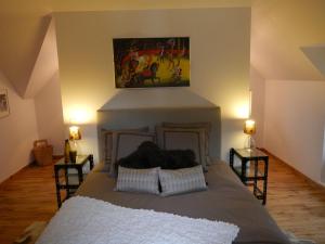 1 dormitorio con 1 cama con una pintura en la pared en L'appartement du Manoir, en Gauciel