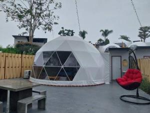 a tent on a patio with a table and a chair at ไร่ไปรยา แก่งกระจาน in Ban Wang Malako
