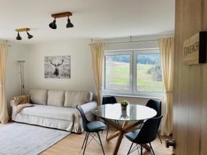 sala de estar con mesa y sofá en Ferienwohnungen Greve en Baiersbronn