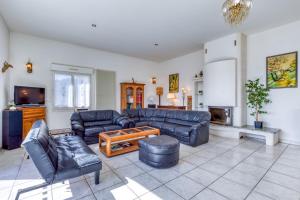 uma grande sala de estar com sofás e uma televisão em Villa F5 Jardin, Piscine em Saint-Gély-du-Fesc