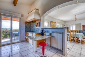 a kitchen with a counter and a dining room with a table at Villa F5 Jardin, Piscine in Saint-Gély-du-Fesc