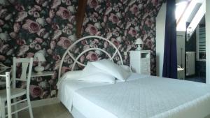 a bedroom with a bed with a floral wall at Chambres d'hôtes Le Saleix in Donzenac