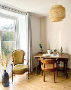 una scrivania e una sedia in una stanza con finestra di l'amour, le rire et la famille a Hillion