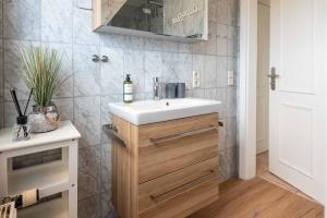 a bathroom with a white sink and a mirror at SyltStern Haus Hasenkuhle in Wenningstedt