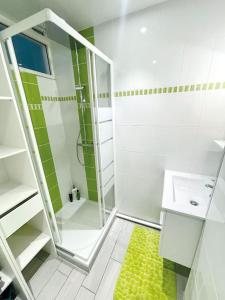 uma casa de banho branca com um chuveiro e um lavatório. em l'amour, le rire et la famille em Hillion