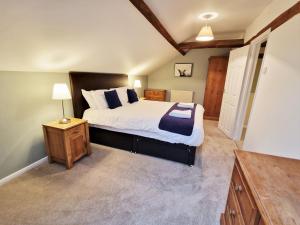 a bedroom with a large bed and a night stand at The Mill in Leighton Buzzard