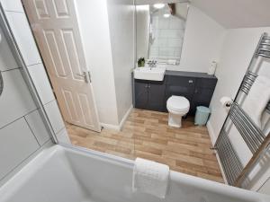 a bathroom with a tub and a toilet and a sink at The Mill in Leighton Buzzard