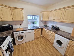 a kitchen with a washer and dryer in it at The Dairy in Leighton Buzzard