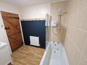 a bathroom with a shower and a bath tub at The Dairy in Leighton Buzzard
