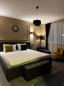 een slaapkamer met een groot bed en een klok aan de muur bij Daily Apartment Prishtina in Pristina