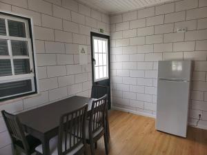 eine Küche mit Tisch und Kühlschrank in der Unterkunft Casa da Villa in Madalena + 11 Fotos