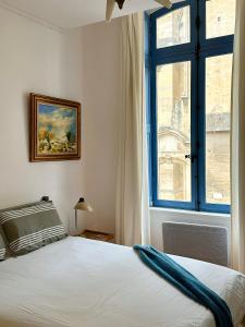 Schlafzimmer mit einem Bett und einem Fenster in der Unterkunft La Suite de la Cathédrale in Narbonne