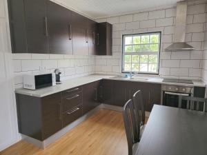 eine Küche mit dunkelbraunen Schränken und einem Fenster in der Unterkunft Casa da Villa in Madalena