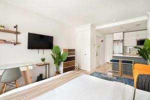 1 Schlafzimmer mit einem weißen Bett und einer Küche in der Unterkunft 1597-7 Luxury Upper East Studio W&D in unit in New York
