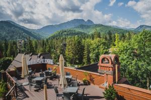 een patio met tafels en stoelen en bergen op de achtergrond bij Hotel Belvedere Resort&SPA in Zakopane